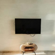 Spacious room featuring a wall-mounted TV in a minimalist style.