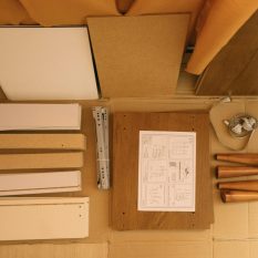 Top view of arranged pieces with instruction paper on carton before assembling furniture at home